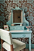 Upholstered chair at dressing table in bedroom of Bovey Tracey family home, Devon, England, UK