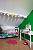 Schlafcouch mit Schminktisch im hellgrünen Schlafzimmer des Hauses der Familie Bovey Tracey, Devon, England, UK