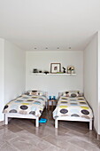Zwillingsbetten mit gepunkteten Bettdecken in einer Nische im Schlafzimmer, modernes Haus, Cornwall, England, UK