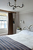 Woollen blanket on metal framed bed in Padstow cottage, Cornwall, England, UK