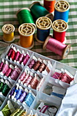 Selection of threads in a variety of colours on checked tablecloth in Padstow cottage, Cornwall, England, UK