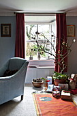Weihnachtsgeschenke und blauer Sessel im Wohnzimmer eines Bauernhauses, Cornwall, England, Vereinigtes Königreich