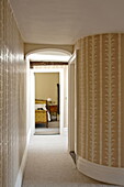 Geschwungene Wand mit Blick durch die Tür zum Schlafzimmer in einem modernen Landhaus in Suffolk, England, UK