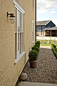 Pot plants on gravel exterior of Suffolk country house, England, UK