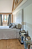 Doppelbett mit gepolstertem Kopfteil und verspiegeltem Nachttisch in einem modernen Haus in Suffolk/Essex, England, UK