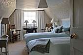 Twin beds in attic room of Bury St Edmunds country home, Suffolk, England, UK