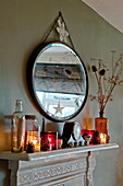 Vintage mirror with lit candles on mantlepiece in Shropshire cottage, England, UK