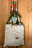 Shoulder bag with heart shaped ornament on cupboard door in Shropshire cottage, England, UK