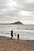 Mother and son walking on beach Penzance Cornwall England UK