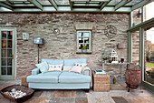 Light blue two seater sofa in stone conservatory of Sherford barn conversion Devon UK