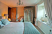 Painted wardrobe and windowseat in bedroom with woollen blanket in Sherford barn conversion Devon UK