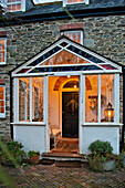 Blick in die beleuchtete Veranda eines Hauses in Crantock, Cornwall, England UK