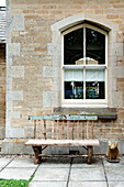 Verwitterte Sitzbank unter dem Fenster eines alten Steinhauses in Stamford Lincolnshire England UK