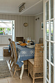 Breakfast table with wicker dining chairs in panelled Penzance farmhouse Cornwall England UK