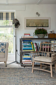 Wooden chair with bookcase in corner of Penzance farmhouse Cornwall England UK