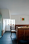 Holzstuhl und Sitzbank mit gestrichenem, blaugrünem Boden in einem Ferienhaus in Cornwall (UK)