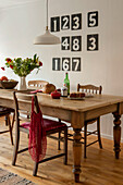 Wooden dining table and chairs with scoreboard numbers in Cornwall cottage UK