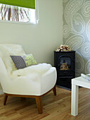 White chair beside woodburner with kindling in UK summerhouse