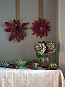 Autumn leaf decorations with hydrangeas in vase on table in UK home