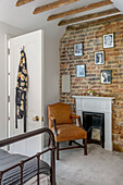 Brauner Ledersessel am Kamin mit freiliegender Ziegelwand in Tunbridge Wells Schlafzimmer Kent England UK