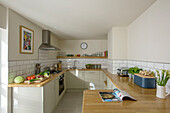 Fresh vegetables on wooden worktop with stainless steel extractor in St Ives kitchen Cornwall UK