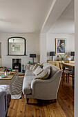 Sofa in living room with wooden floorboards and mirror above fireplace in St Ives home Cornwall England UK