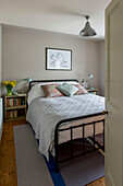 Weiße Bezüge auf einem Bett mit Metallrahmen und Kistenlagerung in einem Haus in St Ives, Cornwall, England