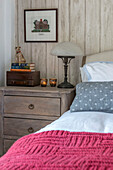 Vintage lamp and tealights on chest of drawers at bedside in Penzance farmhouse Cornwall UK