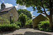 Holztor und Kiesweg auf dem Gelände eines Bauernhauses in Helston, Cornwall UK