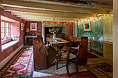 Old fashioned wooden bench seating and table with patterned rugs in Helston farmhouse Cornwall UK