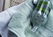 Flasche mit Badesalz auf dem Handtuch liegend