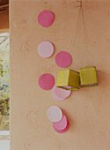 Pink paper dots and green lanterns against a rough plastered wall