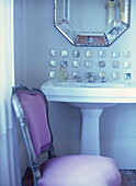 Waschbecken im Badezimmer mit hübschen Perlmuttmosaikfliesen und venezianischem Glasspiegel