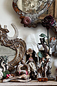Kaminsims mit einer Auswahl an skurrilen Objekten - eine Reihe von Feenpuppen, die liebevoll aus alten Stoffen und Posamenten zusammengestellt und mit alten Knöpfen und anderen Marktfunden verziert wurden