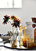 Schnittblumen Rudbeckia und farbiges Glas auf Tablett mit Keramikkrug in Lyme Regis home Dorset UK