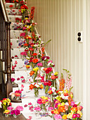 Blumenvasen auf einer Treppe mit Blumentapete