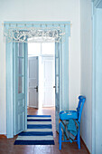 Striped rug on terracotta floor in entrance hall of Greek villa