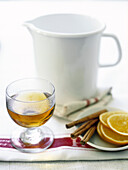 Glas Tee mit Zimtstangen und Orangenscheiben
