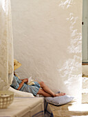 Woman in sunhat in whitewashed courtyard of Spanish villa