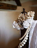 White roses and lace on foot of vintage bed in Sicilian home