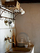 Sauberes Geschirr und Wandregal über der Spüle in einem sizilianischen Haus