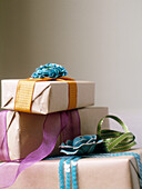 Three presents wrapped in brown paper and tied with ribbon