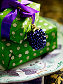 Gifts wrapped in bright green spotted paper with small bauble and ribbon