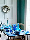 Collection of blue glassware with silver candlesticks on table