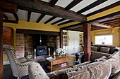 Yellow living room with beamed ceiling in timber framed cottage, Grafty Green, Kent, England, UK