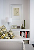 Geometric patterned cushions on leather sofa with storage alcove and artwork in St Leonards beach house, East Sussex, England, UK