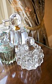 Vintage perfume bottles on side table in bedroom of Cranbrook home, Kent, England, UK