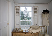 Folded blanket and cushion on wooden table at window in Tenterden home, Kent, England, UK