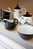 Schwarzes und weißes Teeservice auf Küchenregal in modernem Haus Bath Somerset, England, UK