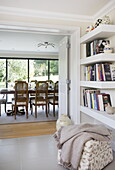 Bücherregale an der Tür zum Esszimmer in einem modernen Bauernhaus, Nuthurst, West Sussex, England, UK